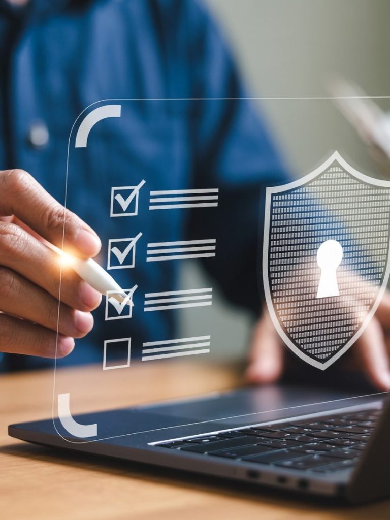 A hand marks a checklist on a digital interface with a shield and keyhole symbol.