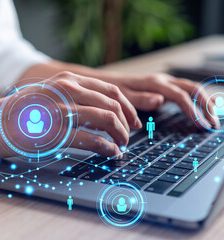 A man with glasses studies digital data on a glowing display.