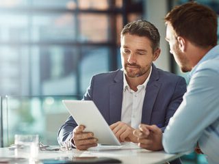 A close-up of a filing cabinet filled with various coloured folders and documents.